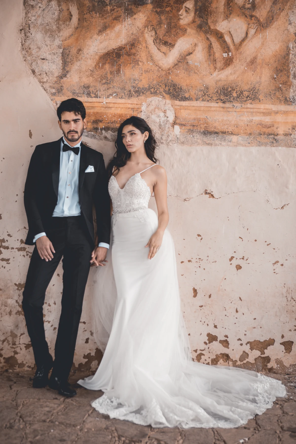 Novios junto a un muro de piedra, fotografía de Edgar Nájera