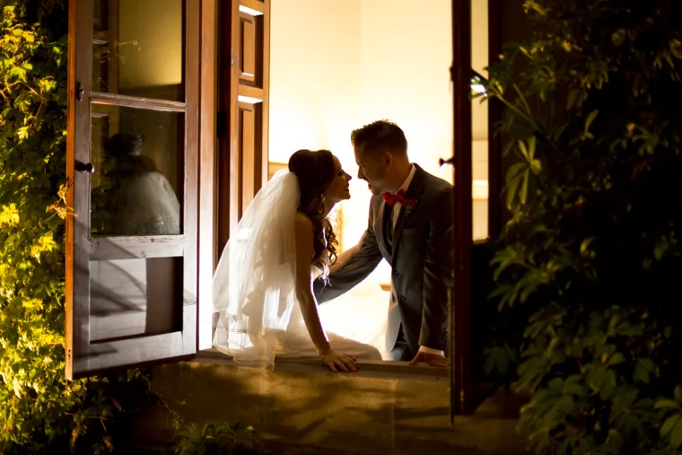 Novios junto a una ventana iluminada