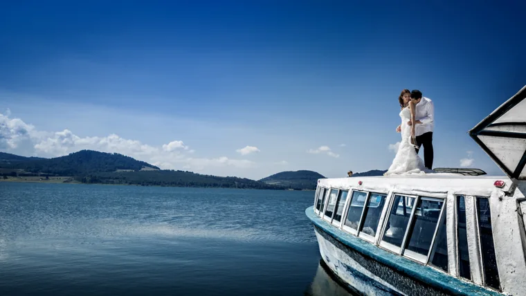 Pareja sobre una embarcación en el lago