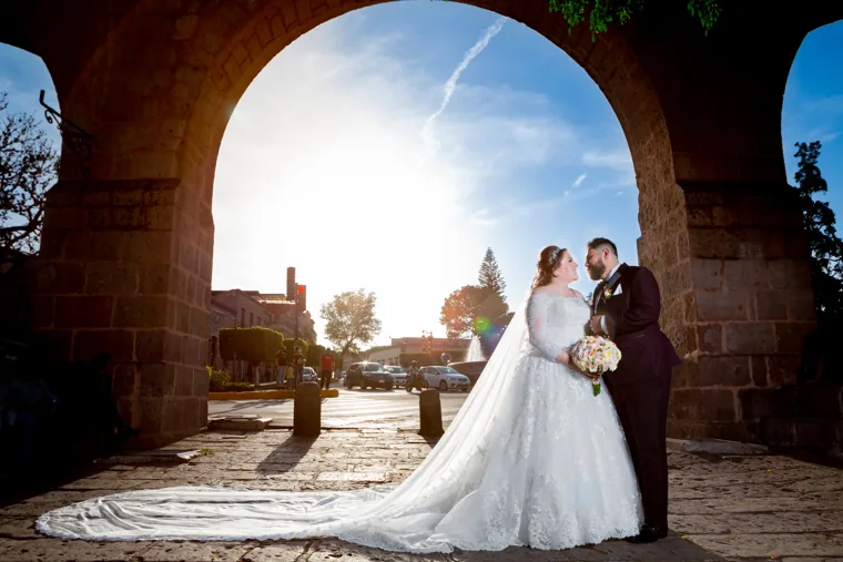 Novios bajo un arco a contraluz